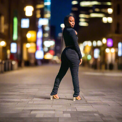 long-sleeve crop top in black stretch nylon material, paired with stacked pants
